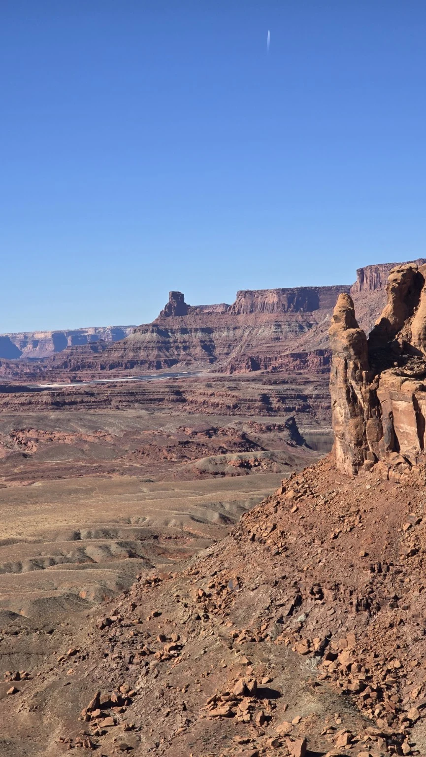 Expansive canyon walls and a rocky desert slope